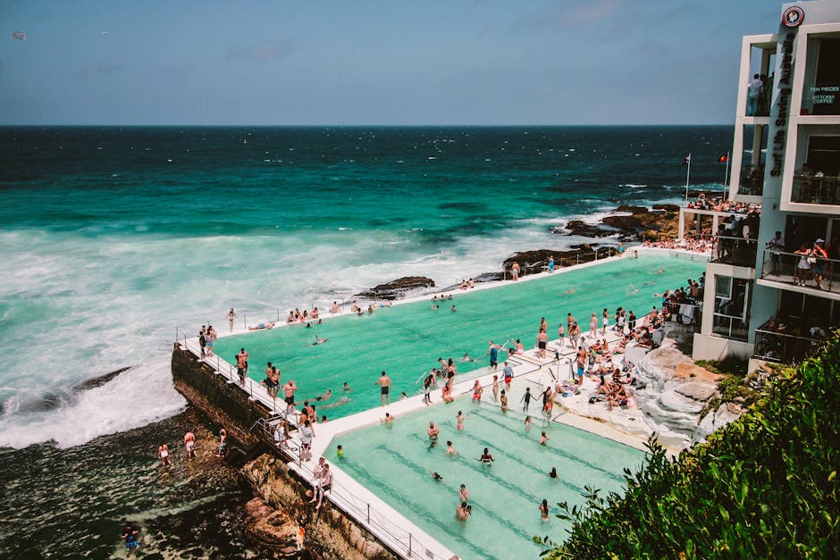 A vibrant scene of people enjoying the Bondi Icebergs swimming pool by the ocean in Sydney, Australia.