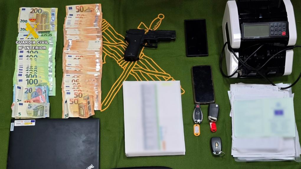 Dinero en efectivo, arma y dispositivos incautados